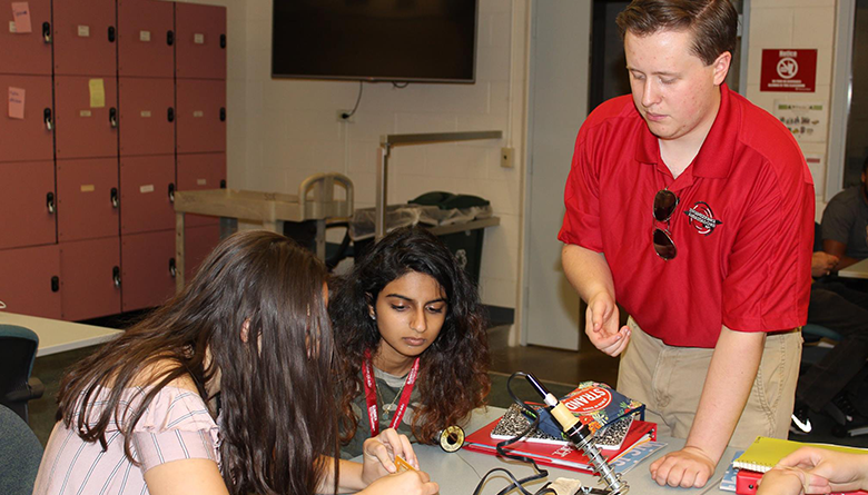 Rensselaer Polytechnic Institute student Ian Steensta working with students on a project.