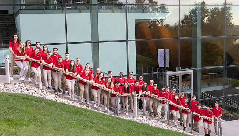 Members of Engineering Ambassadors in red polo shirts on the stairs near EMPAC.